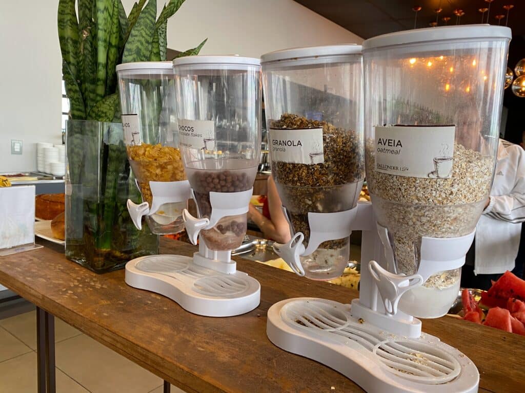 Dispensers com aveia, granola, flocos de cereais e cereais de milho no café da manhã do hotel