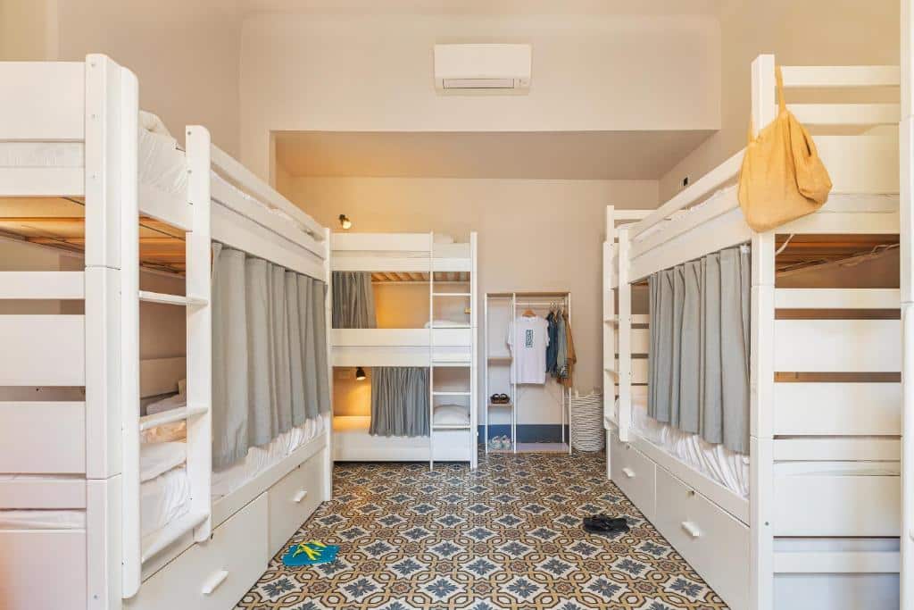 Quarto com duas beliches de duas camas e uma beliche com três lugares, uma arara para colocar roupas e sapatos e piso desenhado, ilustrando post Hotéis em Cinque Terre.