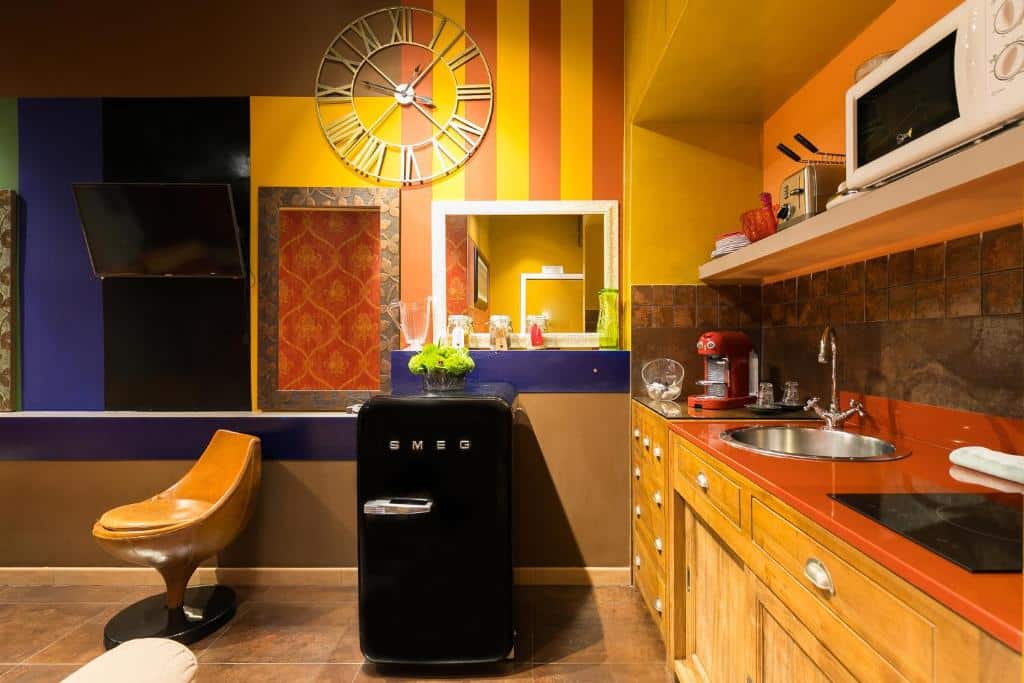 cozinha do apartamento do Appartamenti MarcoAurelio49 com mini geladeira vintage, armários de madeira, relógio de parede e detalhes em preto e amarelo