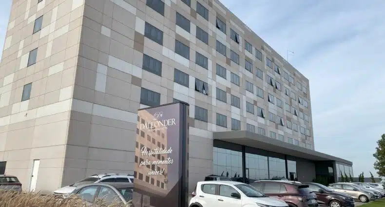 Fachada do Dall'Onder Ski Hotel, em Garibaldi, sendo o prédio retangular, cheio de janelinhas, com estacionamento em frente, onde há alguns carros parados