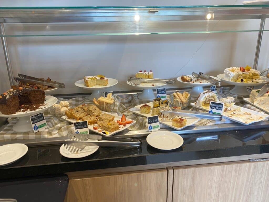 Mesa com diversos tipos de sobremesa no café da manhã do Hotel Laghetto Viverone Estação, uma das opções de onde ficar em Bento Gonçalves