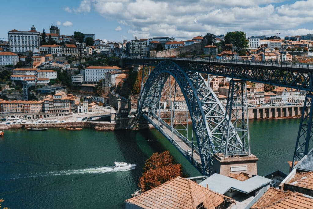 Vista da Ponte D. Luís I durante o dia com a ponte a frente e o rio Douro abaixo dela.
