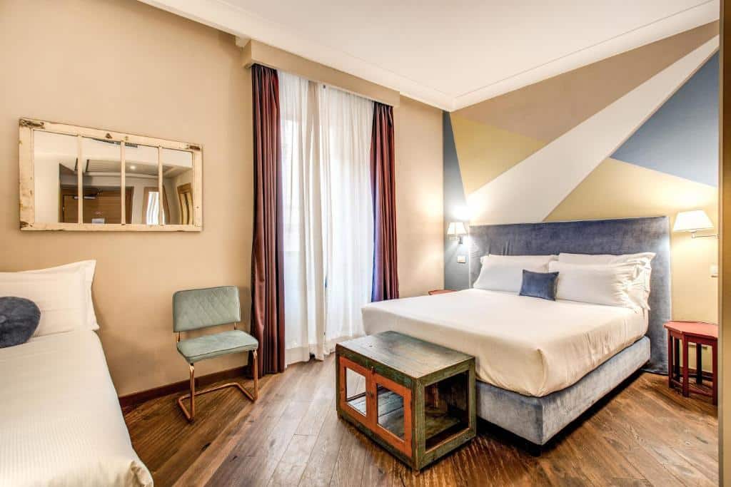quarto do Boutique Hotel Galatea, um dos hotéis bem localizados em Roma, com cama de casal, mesinha e luminária de ambos os lados, com uma cama à frente e espelho
