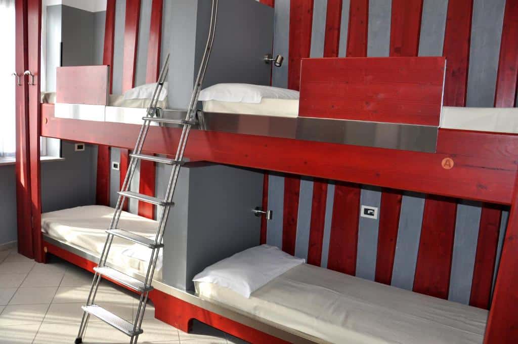quarto do Roma Scout Center, um dos hostels em Roma, com duas beliches e escadinha no meio com detalhes em vermelho