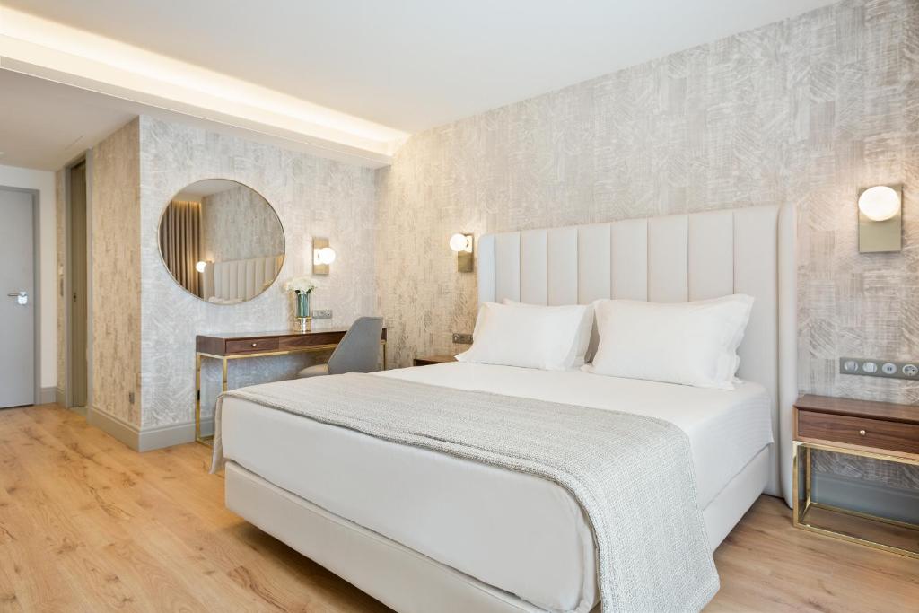 Quarto do Acta The Avenue com cama de casal do lado direito com dias cômodas ao ado da cama e do lado esquerdo do quarto uma mesa de trabalho. Representa hotéis baratos no Porto.