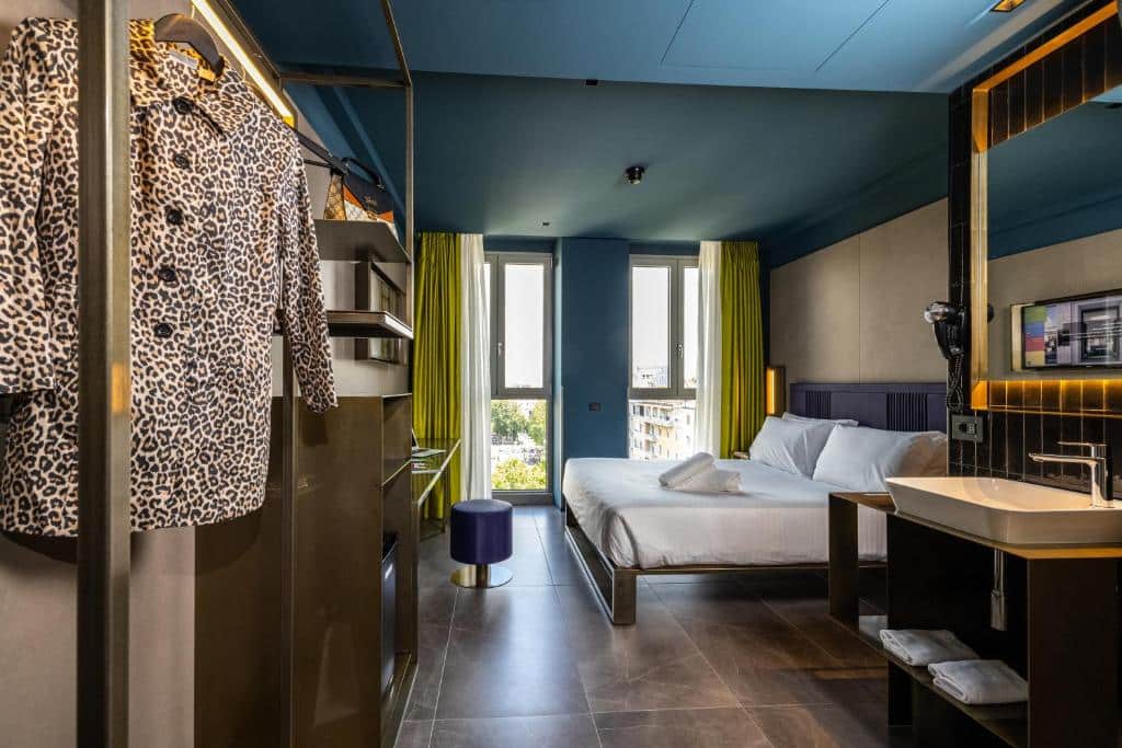 Quarto do HD8 Hotel Milano com duas janelas com cortinas, uma cama de casal, há de frente para a cama, um móvel e uma televisão, para representar hotéis românticos em Milão