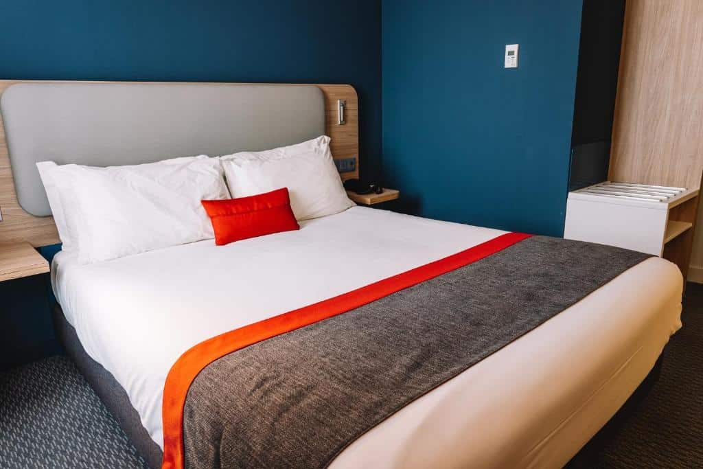 Quarto do Holiday Inn Express Porto City Centre, an IHG Hotel com cama de casal do lado esquerdo. Representa hotéis baratos no Porto.