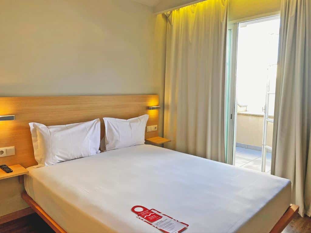 Quarto do Moov Hotel Porto Centro com cama de casal do lado esquerdo. Representa melhores hotéis no Porto.