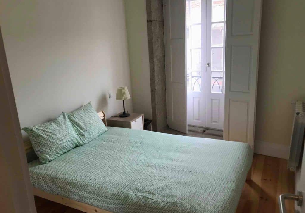 Quarto privado do Onefam Ribeira by Hostel One com cama de casal do lado esquerdo. Representa hostels no Porto.