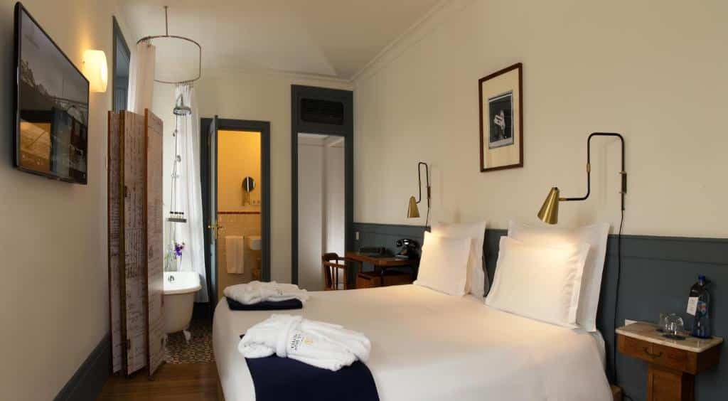 Quarto do Porto A.S. 1829 Hotel com cama de casal do lado direito e duas cômodas ao lado da cama. Representa hotéis boutique no Porto.