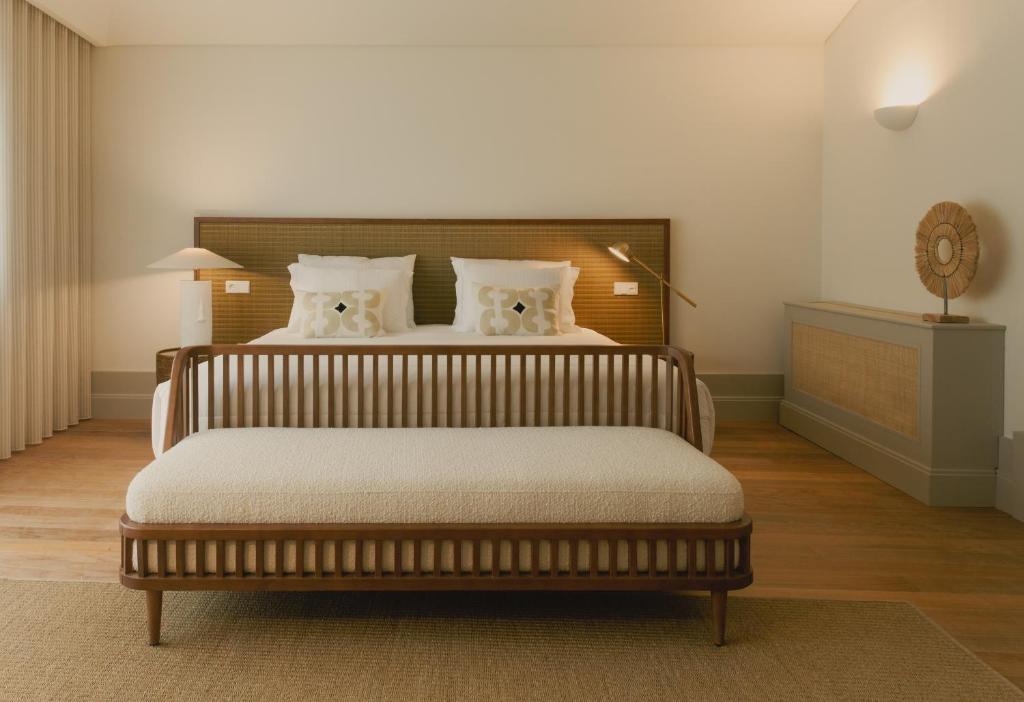 Quarto do Saboaria com cama de casal no centro do quarto e nos pés da cama um banco estofado. Representa melhores hotéis no Porto.