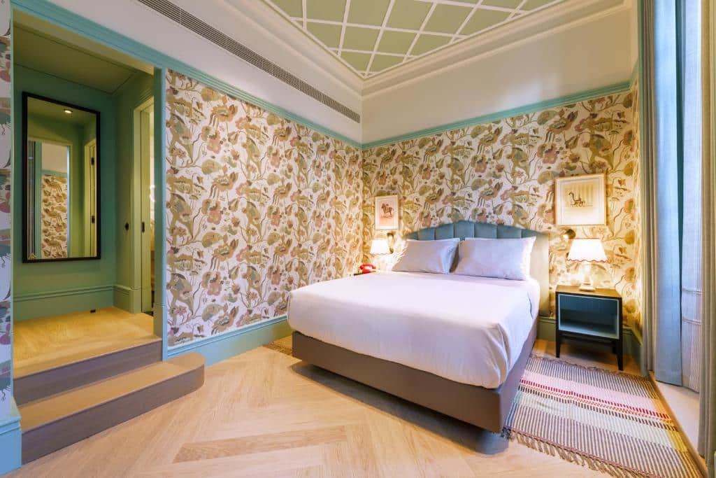 Quarto do The Editory Boulevard Aliados Hotel com cama de casal do lado direito, duas cômodas ao lado da cama com luminária. Representa hotéis românticos no Porto.