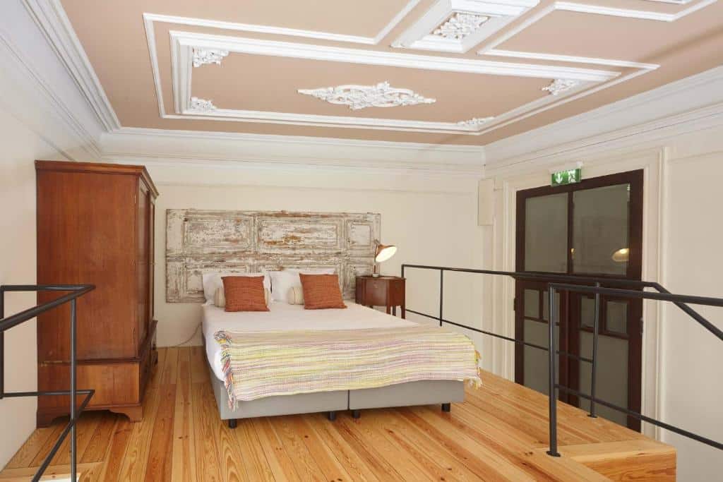 Quarto privativo do The Passenger Hostel com uma cama de casal no centro do cômodo e do lado esquerdo da cama um guarda roupa. Representa hostels no Porto.