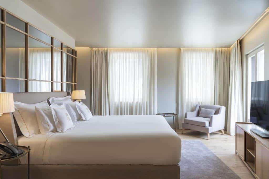 Quarto do Vignette Collection – Casa da Companhia, an IHG Hotel com cama de casal do lado esquerdo, em cada lado da cama uma cômoda com luminária e em frente a cama cômoda com TV. Representa melhores hotéis no Porto.