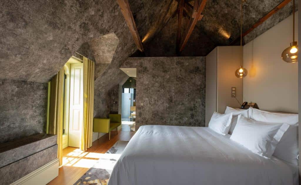 Quarto amplo do Vila Foz Hotel & SPA – member of Design Hotels  com cama de casal do lado direito. Representa hotéis românticos no Porto.