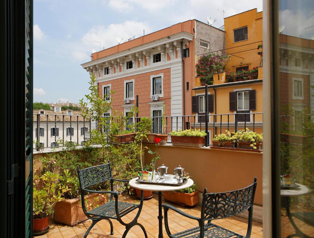 terraço do Hotel Hiberia com duas cadeiras e mesa de ferro escura com plantinhas ao redor e vista da cidade