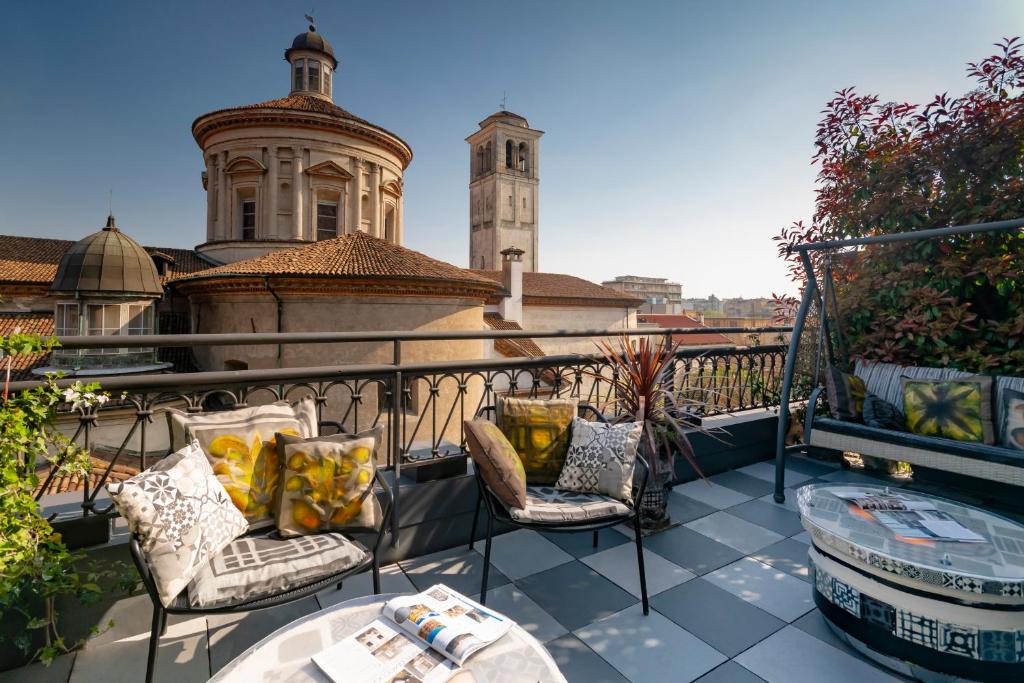 Terraço do B&B Hotel Milano Sant’Ambrogio com cadeiras com almofadas, mesas de centro e uma vista parcial da cidade