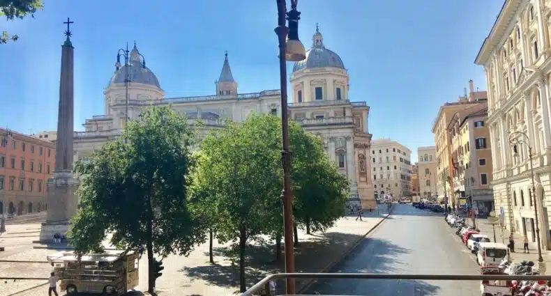 vista do Basilica Hotel, um dos hotéis bem localizados em Roma, em que é possível ver um obelisco na praça e mais prédios históricos