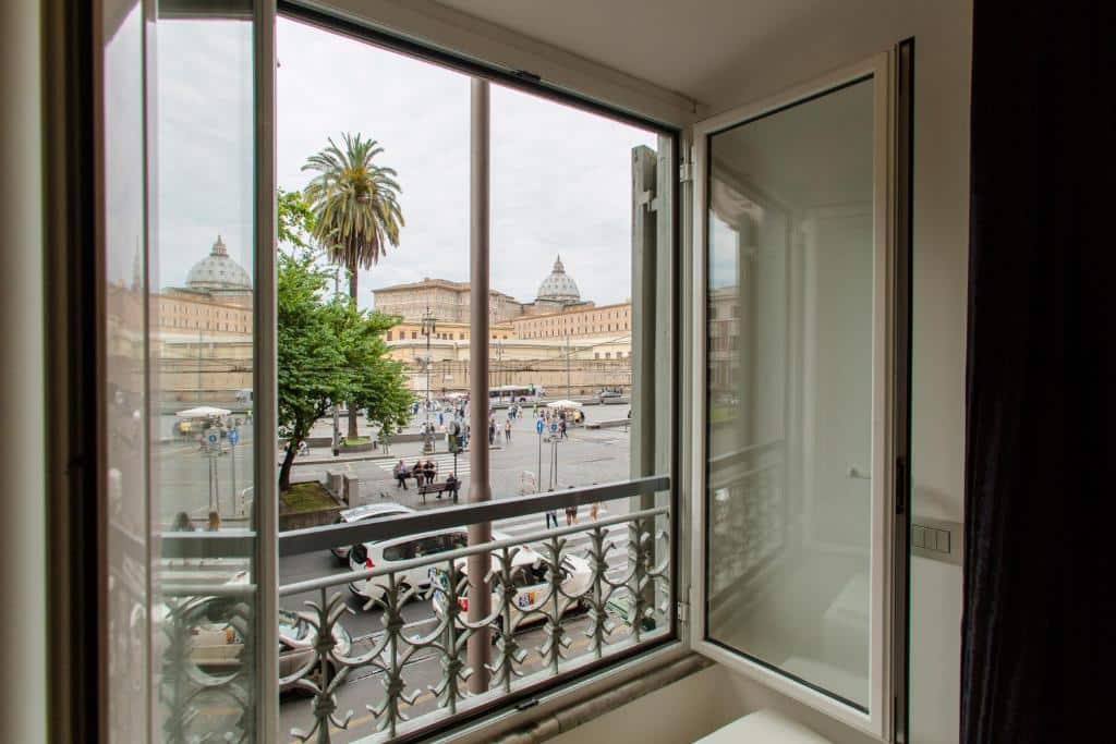 vista do San Pietro Grand Suite a partir de uma janela de vidro comum em que é possível ver a Praça de São Pedro
