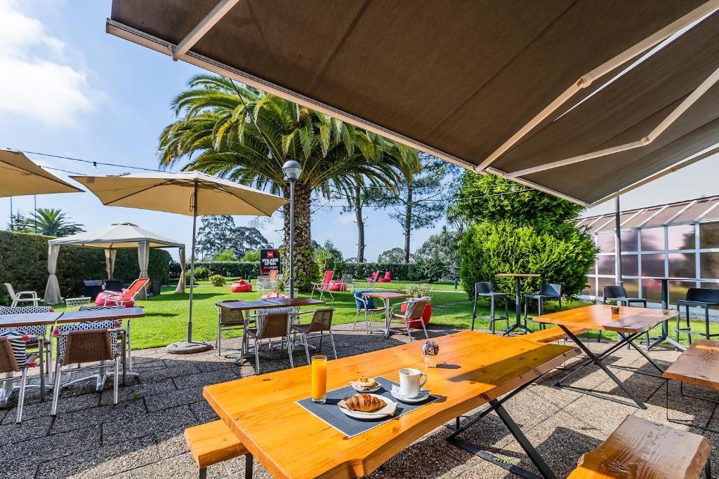 Área de lazer ao ar livre do Hotel ibis Porto Gaia  mesas com cadeiras a frente.