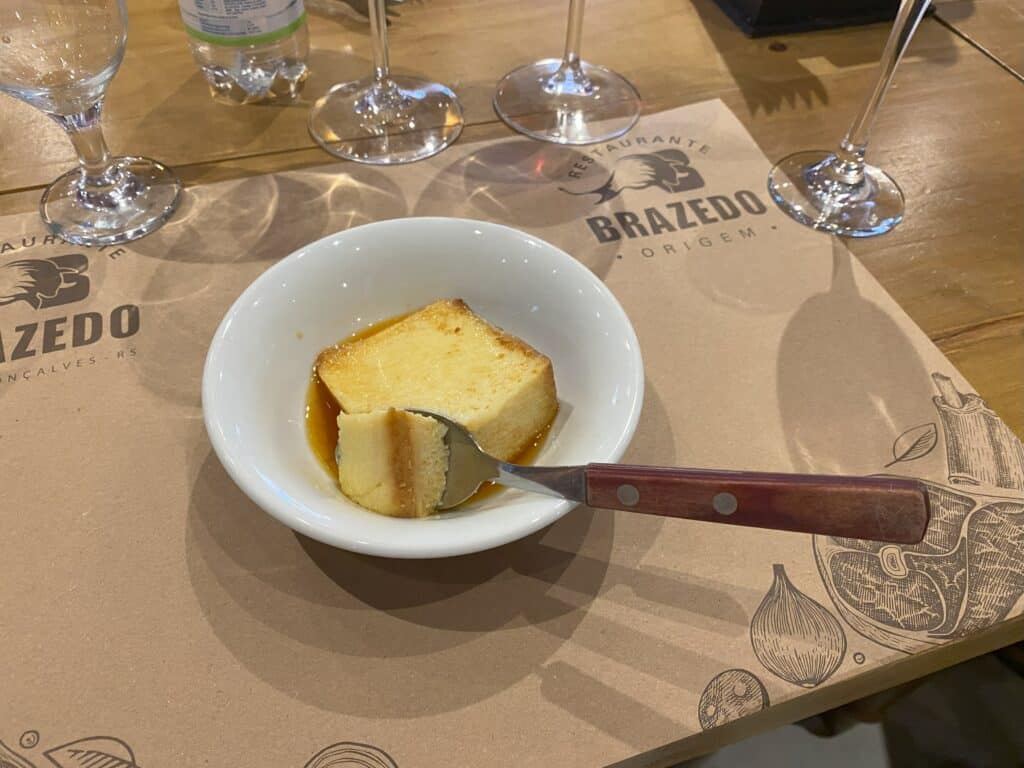 Pratinho de sobremesa do BraZedo com pudim e uma colher