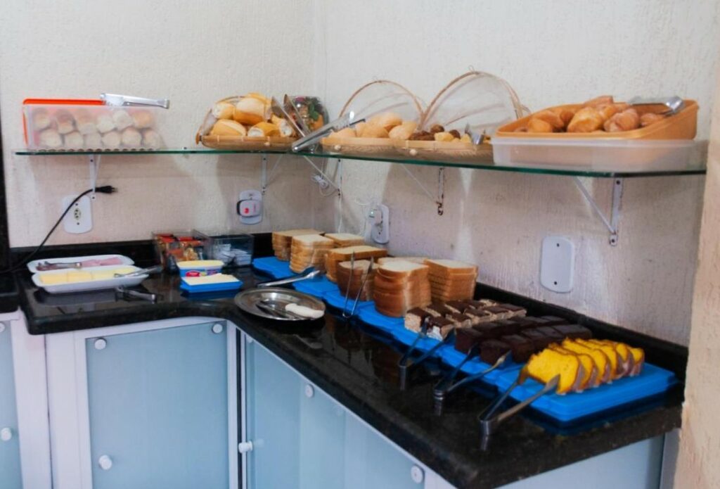 Café da manhã do Hotel Naturalis Eireli. Uma bacada com pães, bolos e frios.