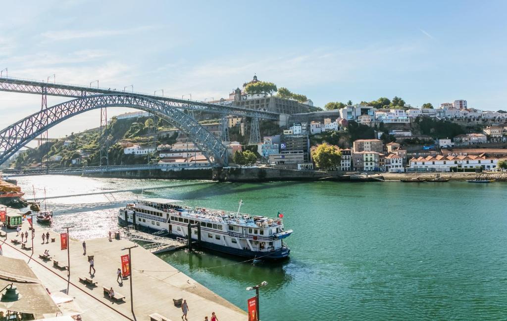 Barco dentro do rio Douro durante o dia em frente ao Porto River. Representa onde ficar no Porto.