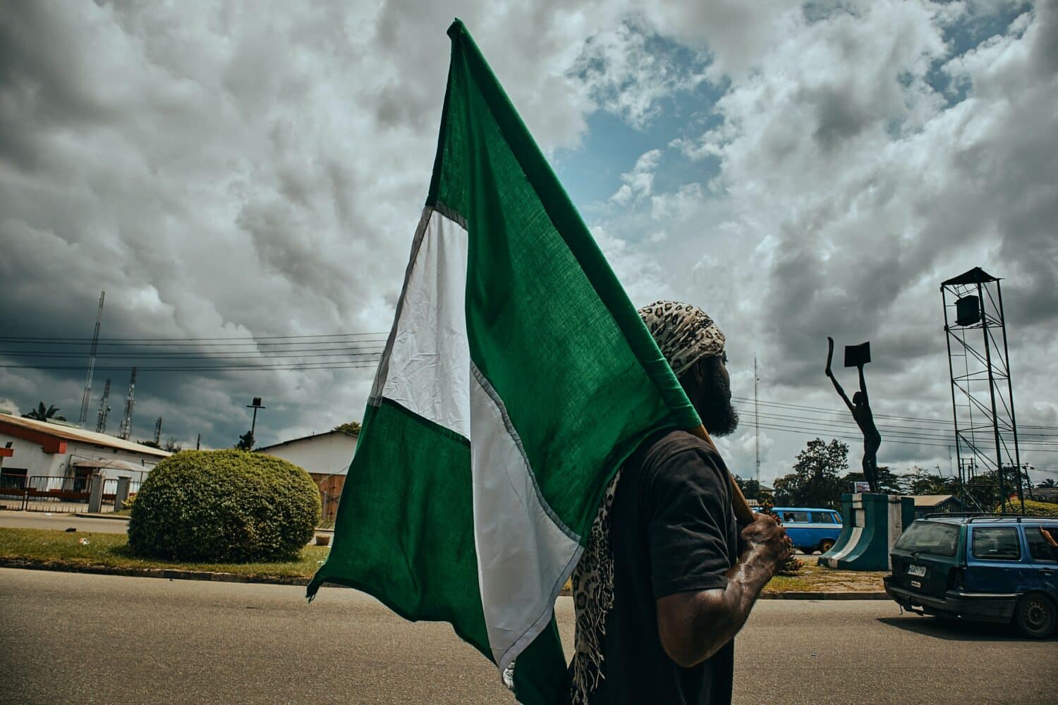 Homem segurando a bandeira na Nigéria durante o dia. Representa seguro viagem Nigéria.