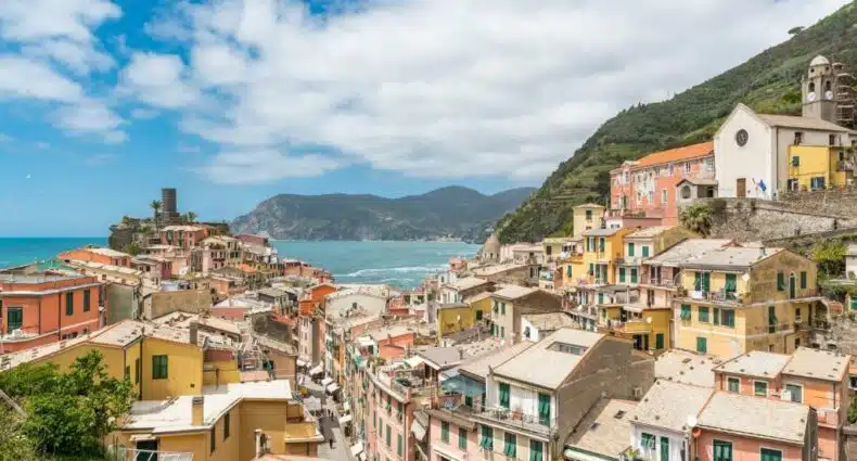 Vista do hotel Casa Catò com várias casas coloridas todas juntas, mar azul bem ao fundo e ao lado direito uma montanha verde, ilustrando post Hotéis em Cinque Terre.
