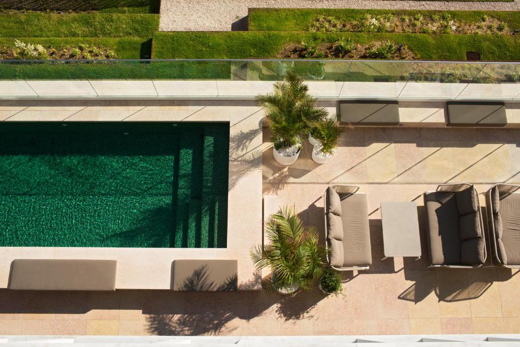 Vista aérea da piscina do Memmo Príncipe Real - Design Hotels com alguns sofás e vasos de plantas no entorno da piscina