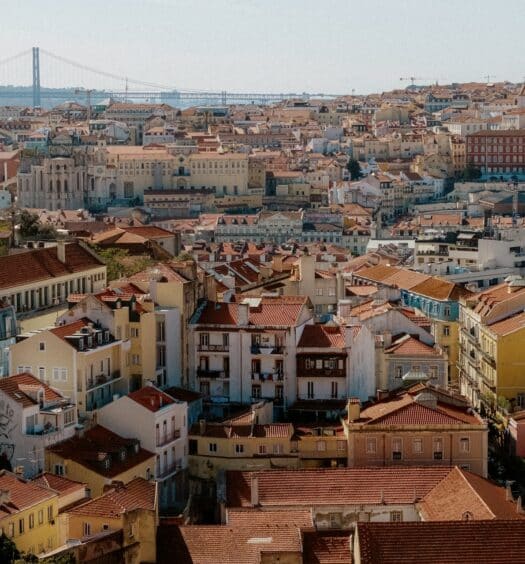 Visão alta da região do Chiado em Lisboa onde há muitos pontos turísticos de época, em construções antigas com telhados laranjas, para representar hotéis no Chiado em Lisboa