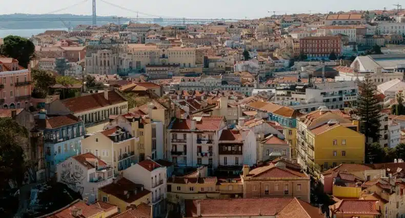 Visão alta da região do Chiado em Lisboa onde há muitos pontos turísticos de época, em construções antigas com telhados laranjas, para representar hotéis no Chiado em Lisboa