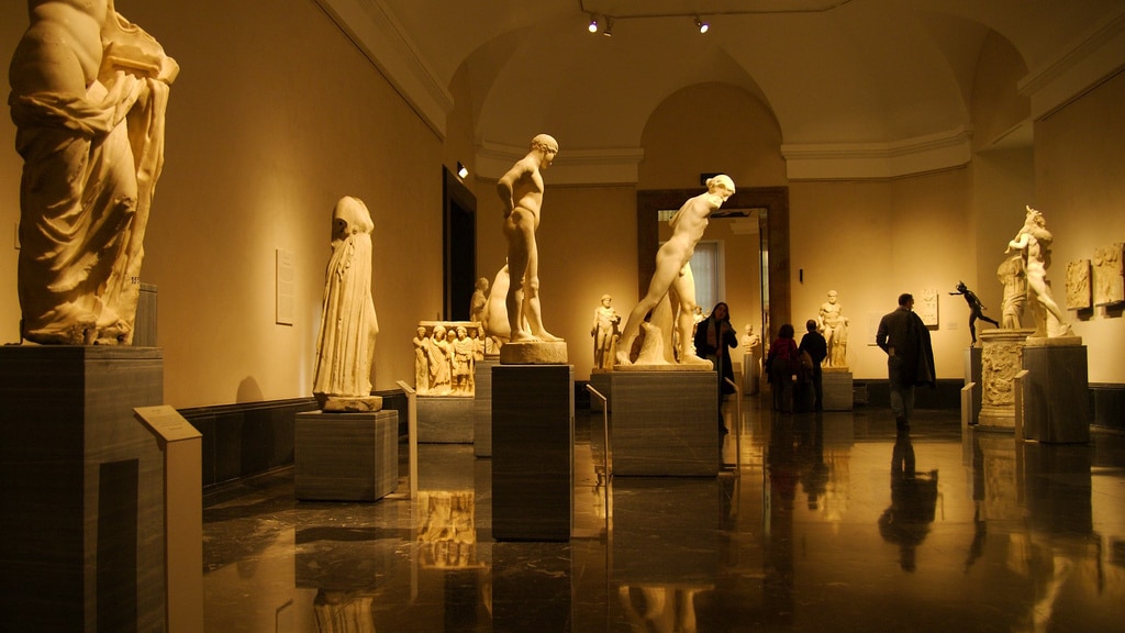 Algumas obras no interior do Museu do Prado. Estátuas de pedra branca são admiradas por pessoas que passeiam por ali. - Foto: van Ort via Wikimedia Commons