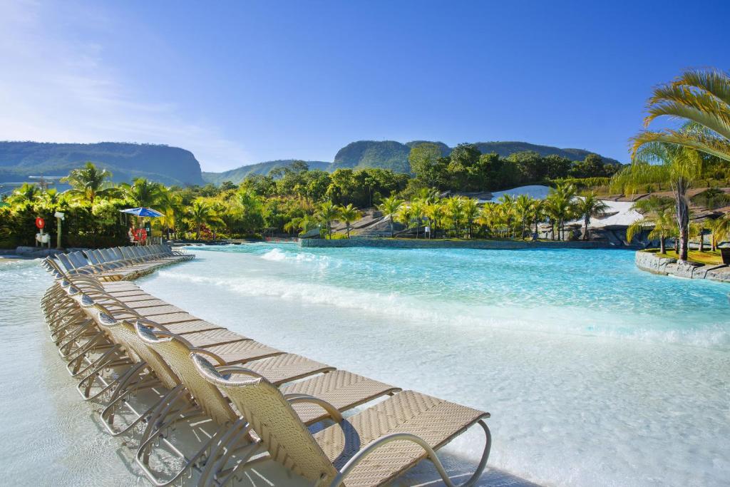 Vista da piscina do Rio Quente Resorts – Hotel Turismo em resorts no Rio Quente durante o dia com cadeiras do lado esquerdo e piscina do lado direito.