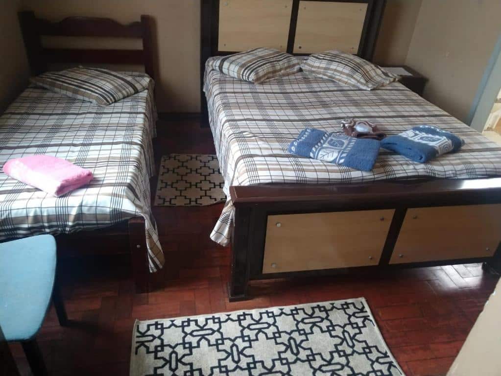 Uma foto na Pousada Líder, para ilustrar o post sobre pousadas em Águas de São Pedro. Podemos ver uma cama de casal, com toalhas em cima, e outra cama de solteiro ao seu lado.