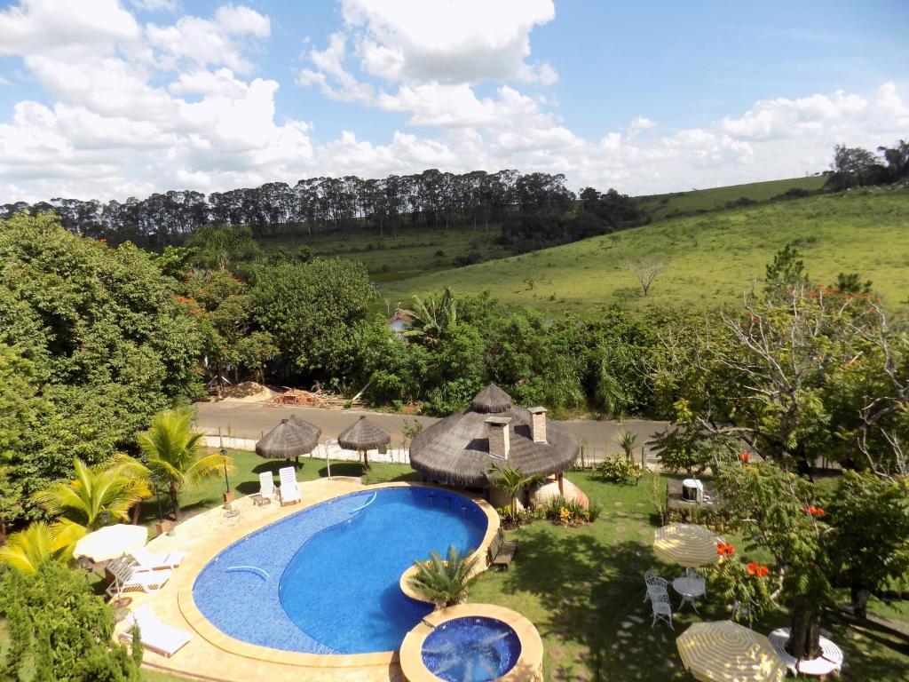 Imagem aérea da Pousada Rural Paraíso. Temos a visão das piscinas, quiosques, mesas e árvores e gramado do recinto.