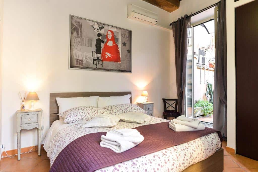 quarto do Malva, um airbnb em Roma, com cama de casal grande, mesinha e luminária de ambos os lados da cabeceira, quadro na parede moderno e janela grande com cortinas e vista