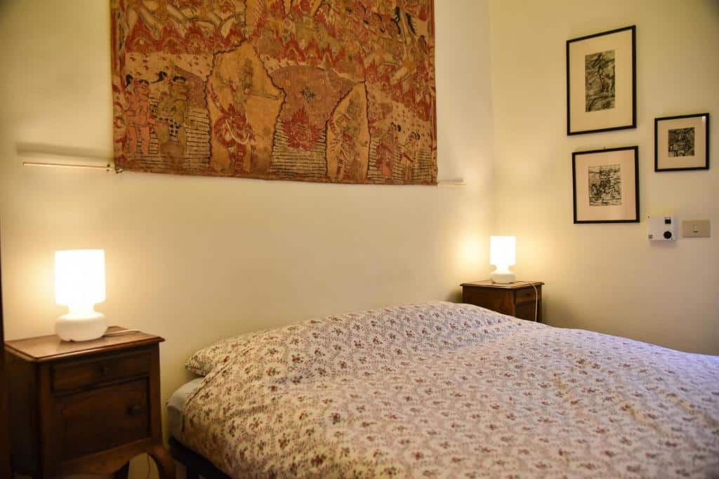 quarto do Stylish apartment in central Rome "Centro Storico", um airbnb em Roma, com cama de casal, mesinha e luminária em ambos os lados da cabeceira, com quadro na parede
