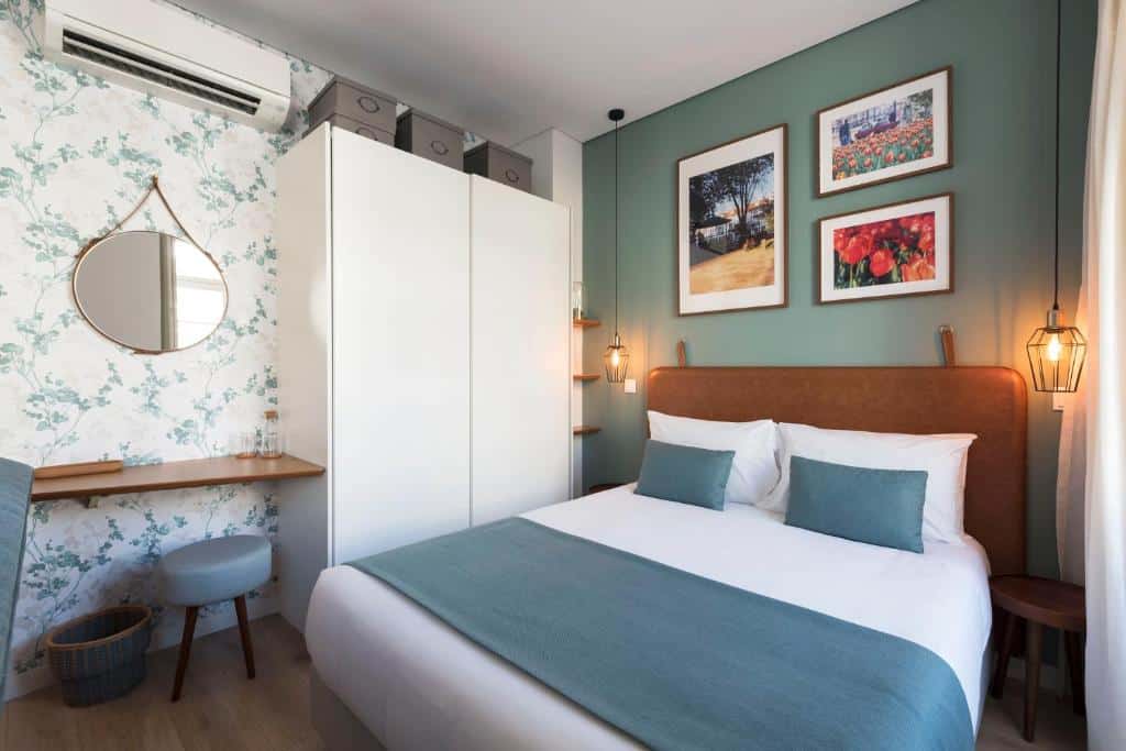 Quarto do Bloom House by Sweet Porto com cama de casal do lado direito, do lado esquerdo da cama um armário branco e ao lado do armário. Representa aluguel de temporada no Porto.