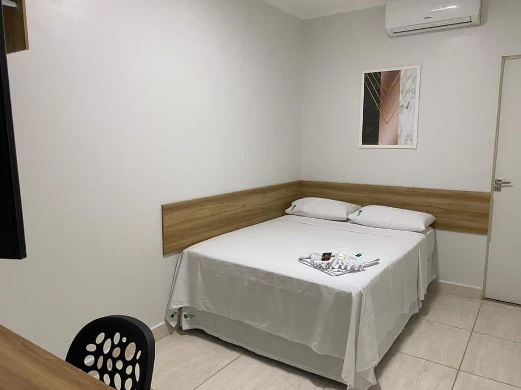 Quarto da Pousada Trevo Caruaru. No canto esquerdo da parede está encostada a cama e é possível ver uma parte da TV, mesa e cadeira. Imagem para ilustrar o post hotéis em Caruaru.