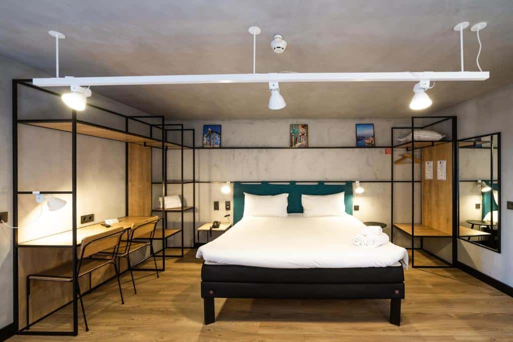 Quarto do ibis Porto Centro Mercado Bolhao com cama de casal do centro do quarto, do lado esquerdo da cama uma mesa de trabalho. Representa hotéis com vista do Douro.