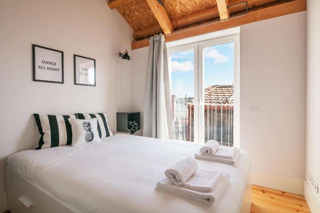 Quarto do Indulge Porto Flats com cama de casal dolado esquerdo da imagem. Representa airbnb no Porto.