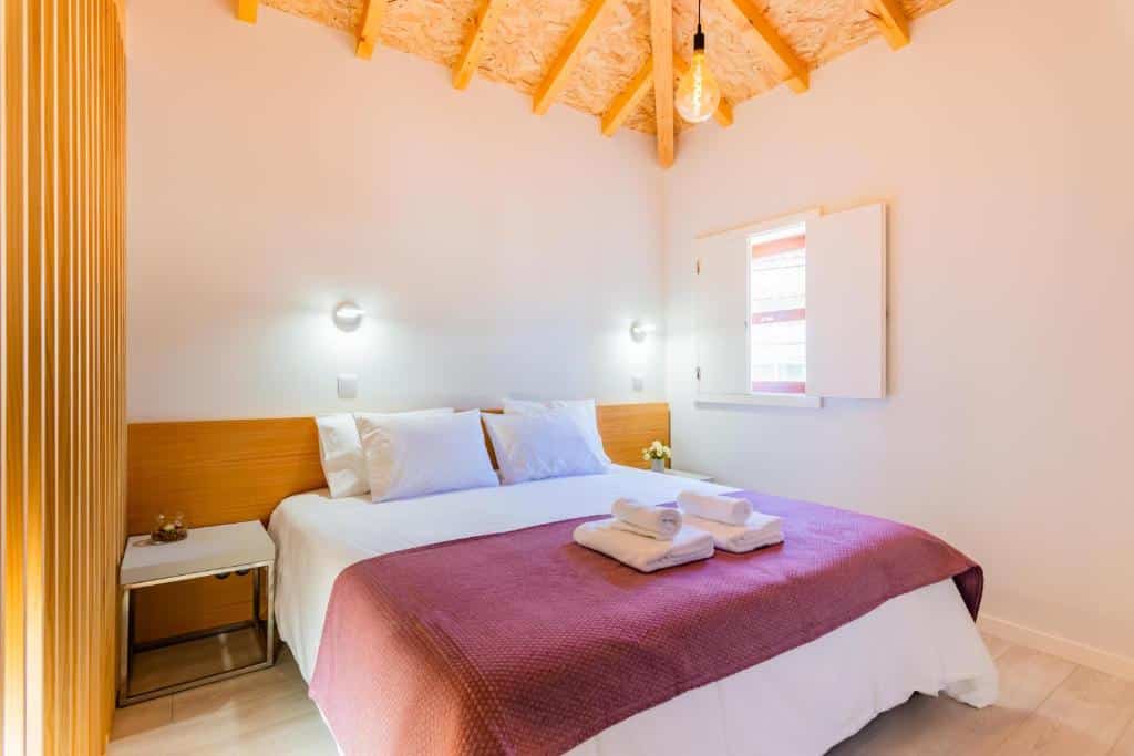 Quarto do Lemago Porto Apartments – São Bento com cama de casal do lado esquerdo da imagem e ao lado da com duas cômodas. Representa aluguel de temporada no Porto.