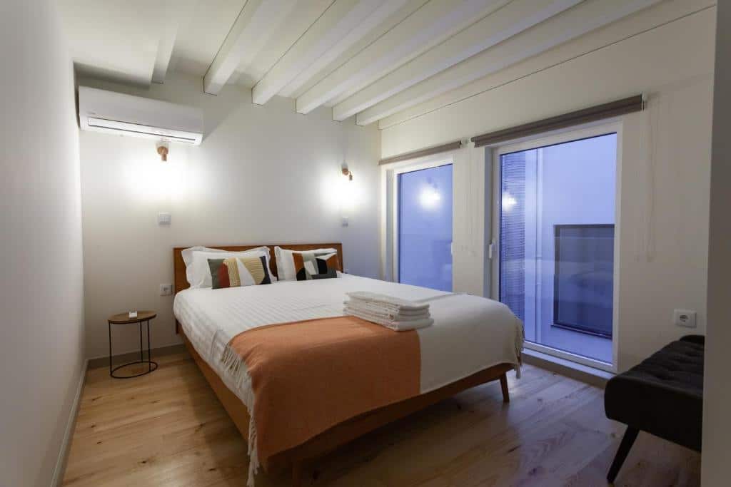 Quarto do Oporto City View- Trindade luxury com cama de casal do lado esquerdo da imagem. Representa aluguel de temporada no Porto.