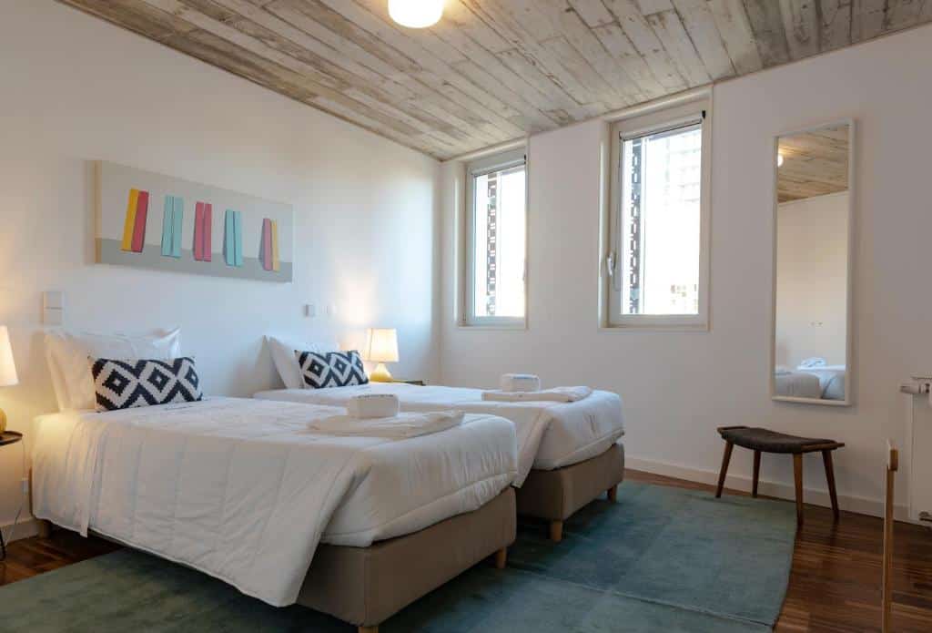 Quarto do PortoSoul Trindade com duas camas de solteiro do lado esquerdo da imagem. Representa airbnb no Porto.