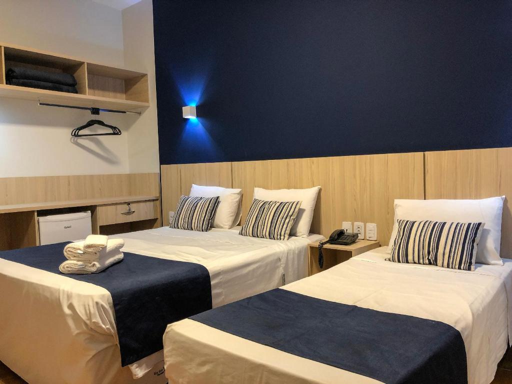 Quarto da Rio das Pedras Thermas Hotel com cama de casal do lado esquerdo da imagem, uma cômoda ao meio e do lado uma cama de solteiro.