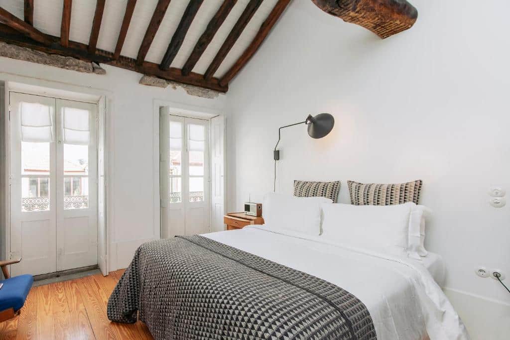 Quarto do Rosa et Al Townhouse com cama de casal do lado direito. Representa onde ficar no Porto.