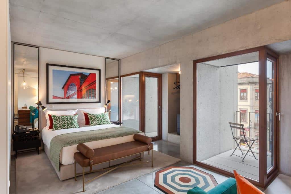 Quarto do S.Bento Residences com cama de casal do lado esquerdo com duas cômodas ao lado da cama com luminária, no pé da cama um sofá. Representa airbnb no Porto.