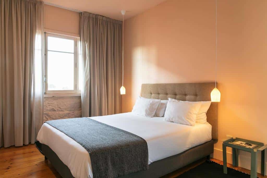 Quarto do Slowly Garden House  com cama de casal do lado direito e uma cômoda do lado direto da cama. Representa airbnb no Porto.
