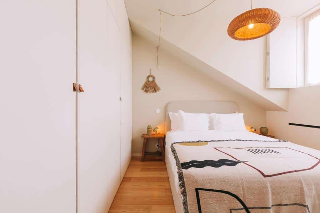 Quarto do Village Aparthotel By BOA com cama de casal do lado direito com duas cômodas ao lado da cama. Representa airbnb no Porto.